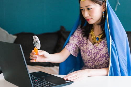 パソコンでオンライン手相占いをする女性占い師