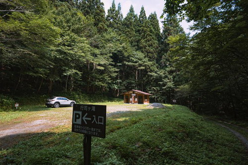 行司ヶ滝の駐車場と森の入り口、管理棟とトイレ施設
