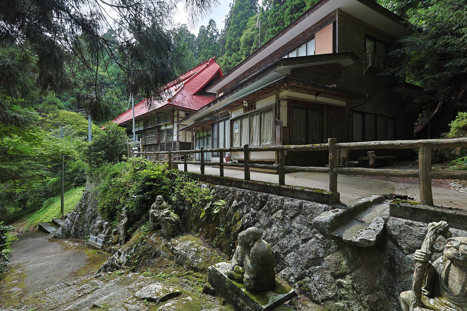 赤い瓦屋根と木造建築の東堂山満福寺の参道と建物
