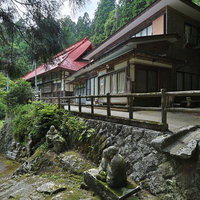 東堂山満福寺の赤い瓦屋根と参道の建物と緑の景観の写真
