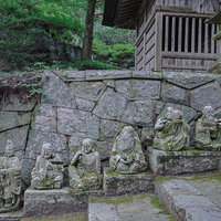 東堂山満福寺の石段に並ぶ羅漢像と苔むした石垣の写真