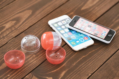 スマホでガチャ課金する瞬間、木製テーブルの上での廃課金