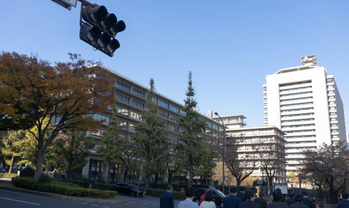 青空をバックにした外務省の近代的な庁舎と街路樹