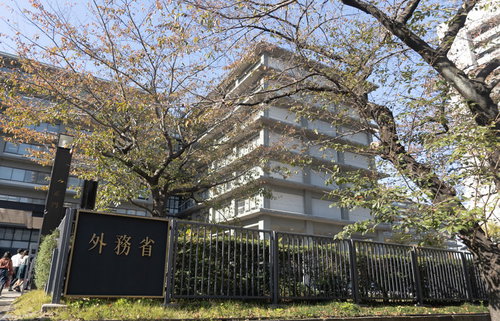 春の外務省庁舎と満開の桜、白い建物と薄紅色の花