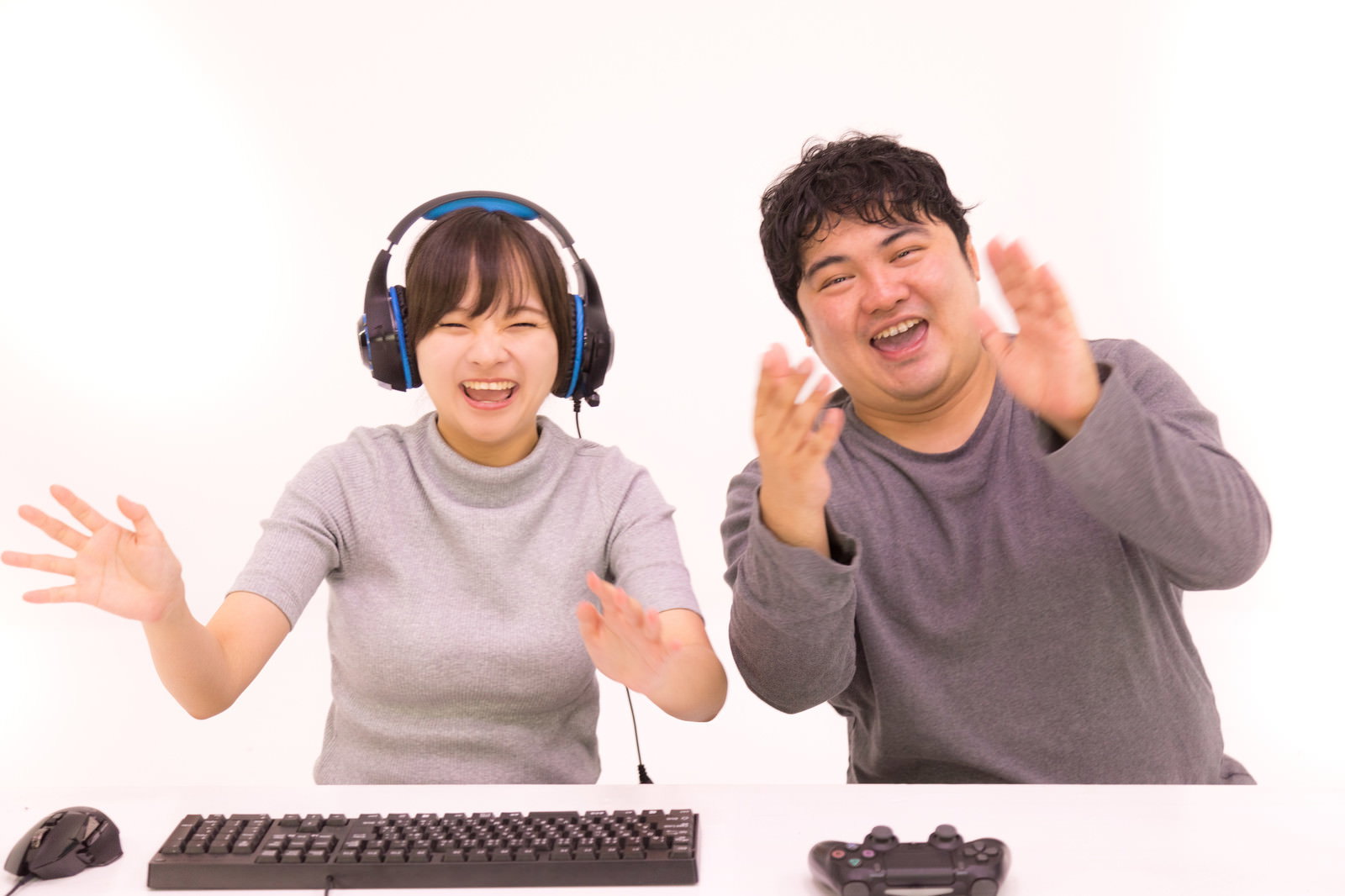 ヘッドセットを着けて笑顔でゲームを楽しんでいる男女［モデル：段田隼人 千歳］