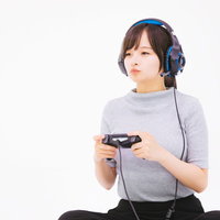 オンライン協力でボイスチャットしながらプレイする女子ゲーマーの写真