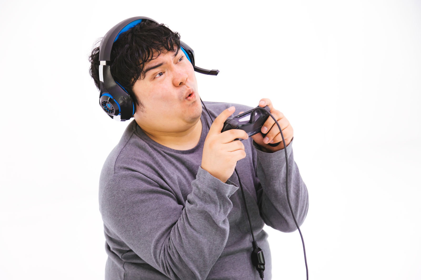 コントローラーを握って真剣にゲームをプレイする男性［モデル：段田隼人］