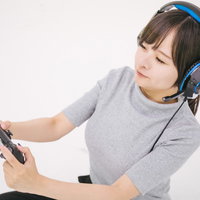PS4のゲームコントローラーを握る夢中の女子ゲーマーの写真