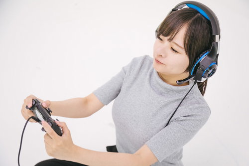 PS4のゲームコントローラーを握る夢中の女子ゲーマー