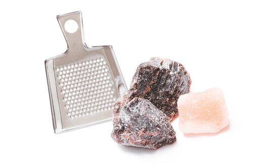 ピンク色と茶色の岩塩とおろし金で塩をすりおろす