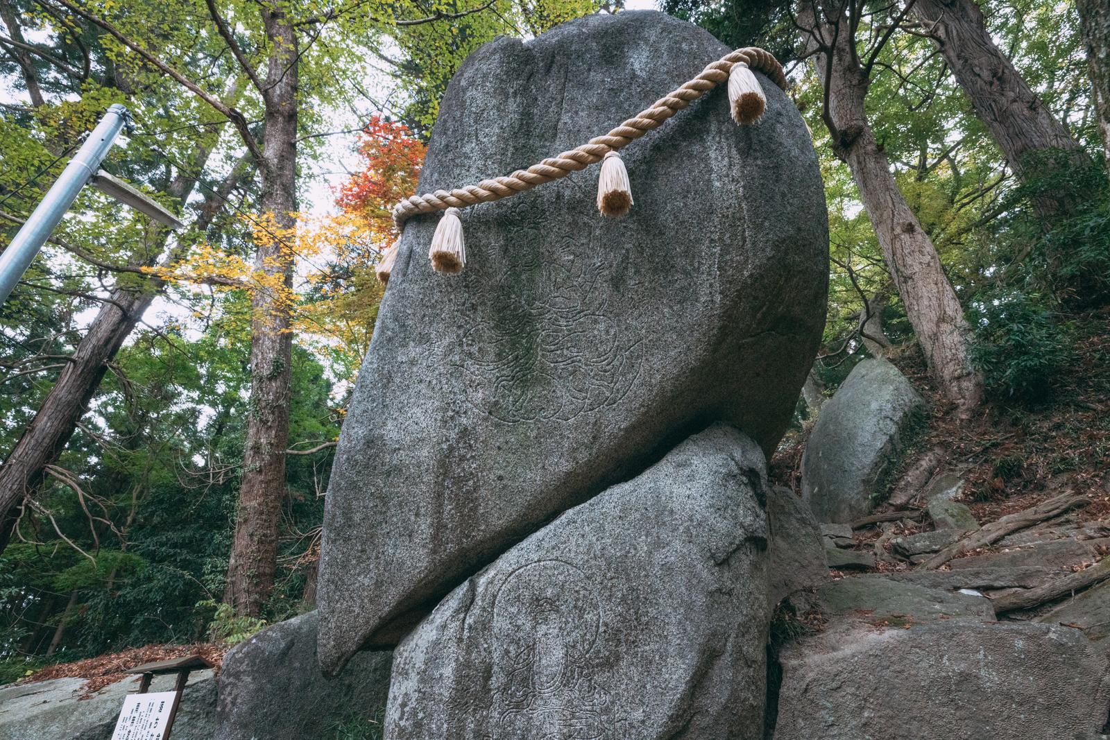 観音菩薩が線刻された巨石に麻縄を結んだ岩角寺の風景