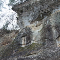 降雪の中、岩壁に刻まれた岩面大佛（平泉）の写真