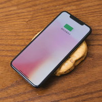 がんもどきの上でワイヤレス充電するスマートフォンの写真