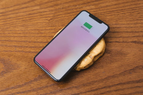 がんもどきの上でワイヤレス充電するスマートフォン