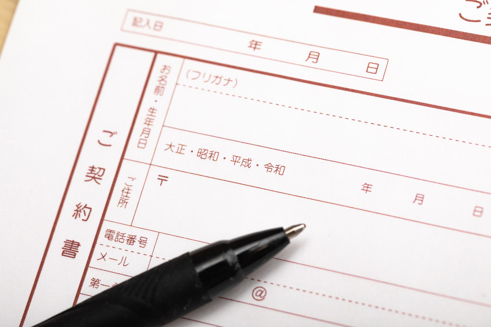 契約書の元号記入欄に黒いペンが置かれた様子