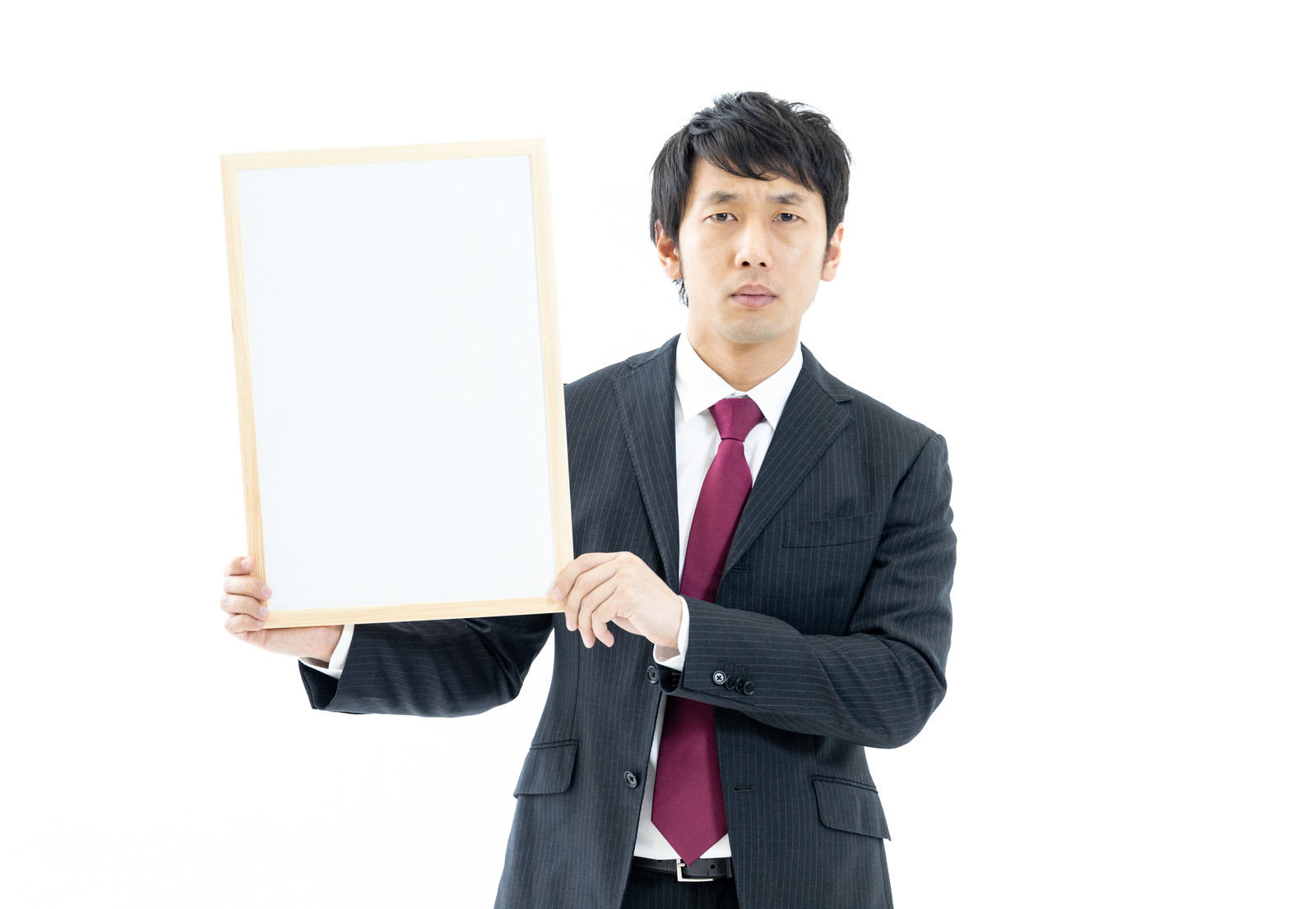 紺色スーツと赤いネクタイを着けた男性が白いフリップボードを持っている［モデル：大川竜弥］