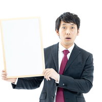 正解者ゼロに唖然と驚く司会者がホワイトボードを持つの写真