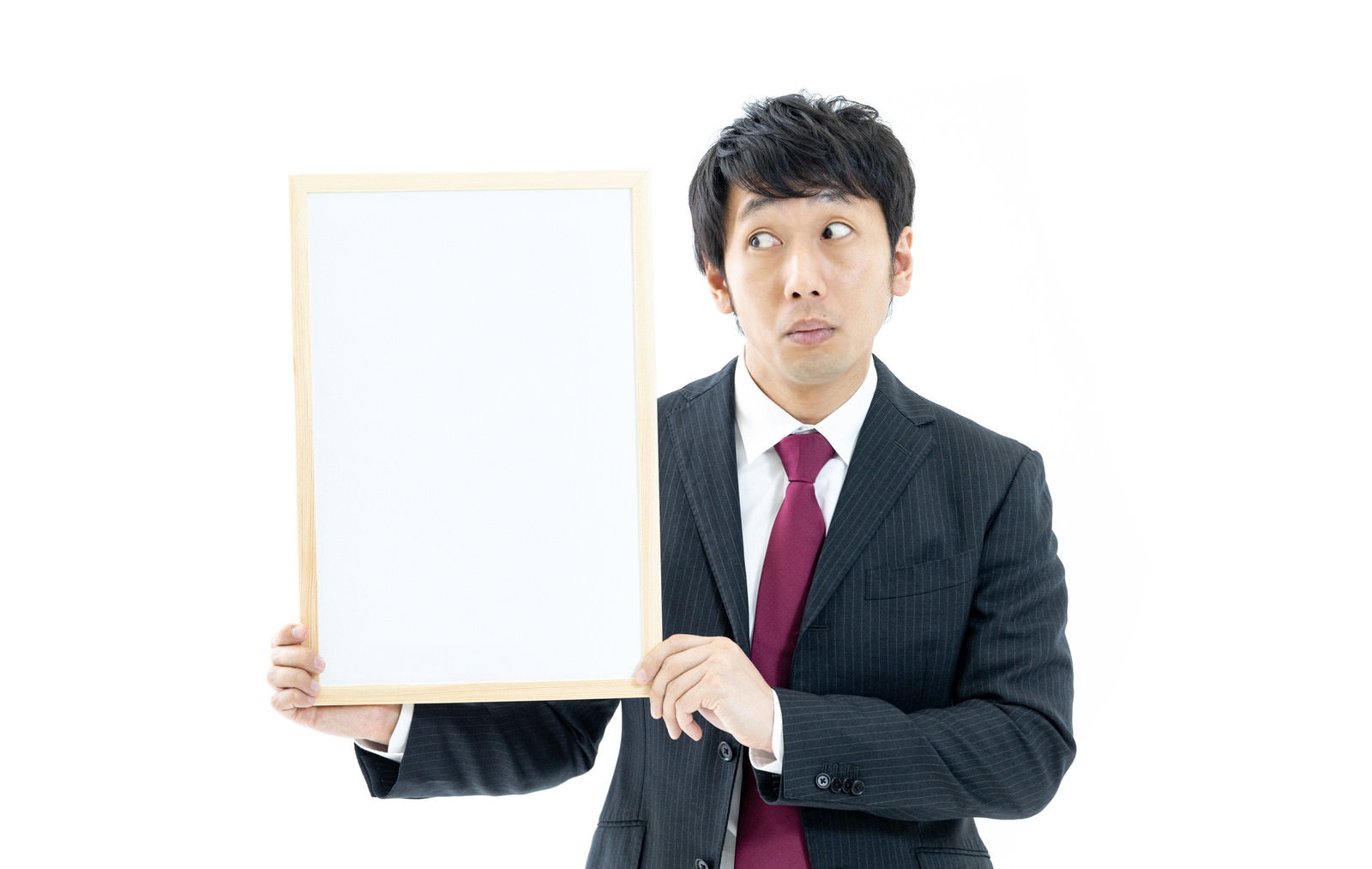 白いホワイトボードを持つ紺色スーツの男性［モデル：大川竜弥］