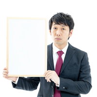 ドヤ顔でフリップを見せる男性の写真