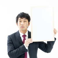 チベットスナギツネの顔マネをしながらホワイトボードを掲げる司会者の写真