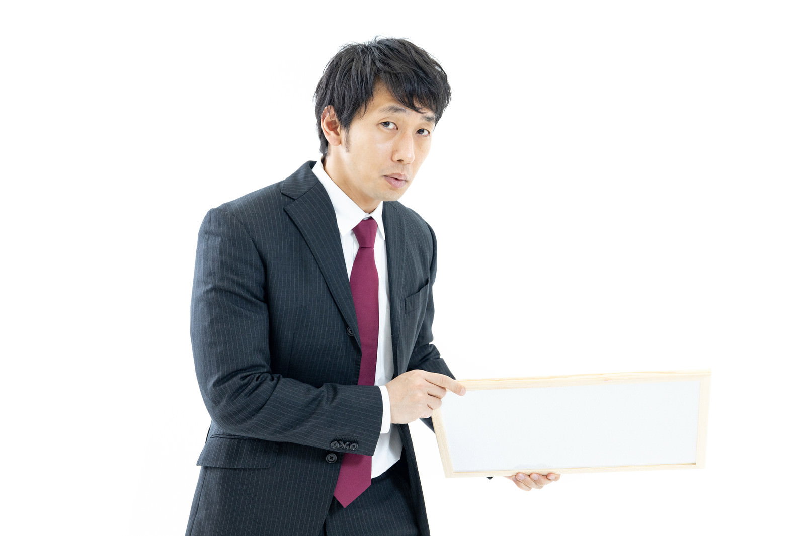 白いフリップボードを持つスーツ姿の男性［モデル：大川竜弥］