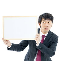 フリップが見えているか不安になるスーツ姿のディレクター男性の写真