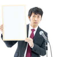 記者の質問に顔がこわばる政治家の記者会見の写真