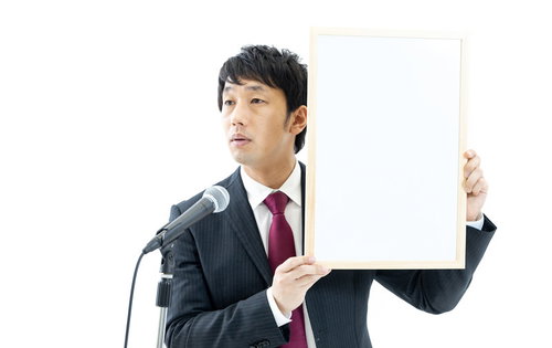 記者の質問に答える政治家がホワイトボードを掲げる