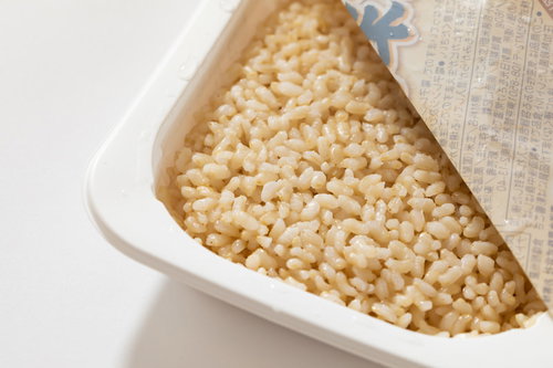 白い容器の玄米レトルト、麻袋と一緒に配置された健康食品