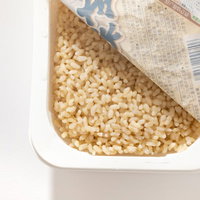 電子レンジで加熱した玄米ごはんパック、レトルト食品の写真