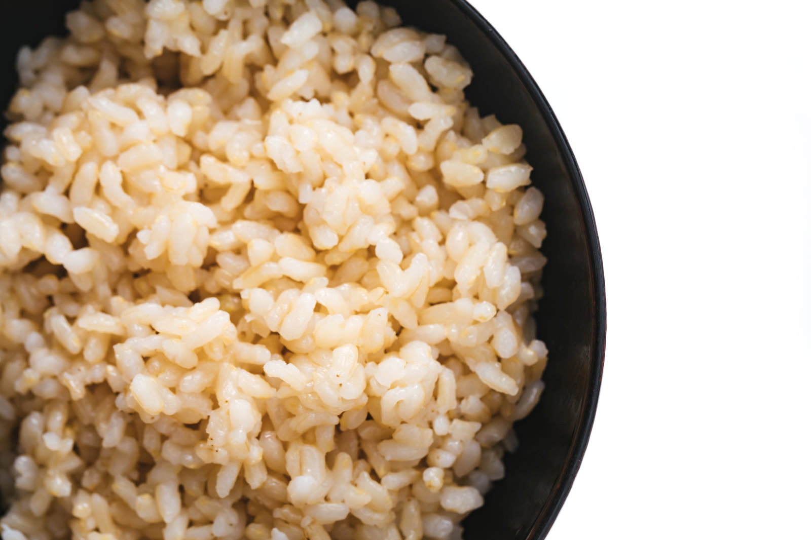 黒い茶碗に盛られたふっくらと炊き上がった玄米