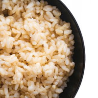 黒い茶碗に盛られた炊きたての玄米ごはん、栄養満点の健康食の写真