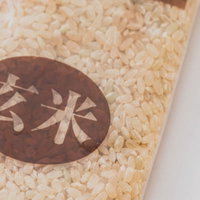 紙袋に入った玄米の粒と穀物の写真