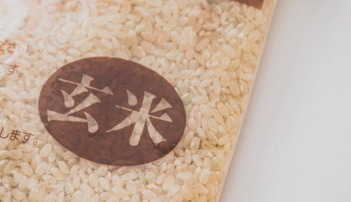 紙袋に入った玄米の粒と穀物