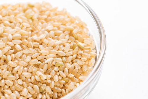 ガラス容器に入った玄米粒と穀物の食材。健康食として注目される玄米