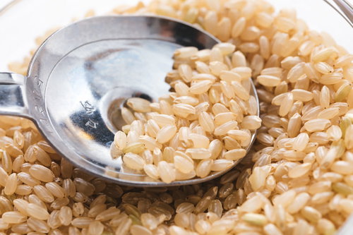 玄米をヘルシーな計量スプーンですくう低GI値の健康食材