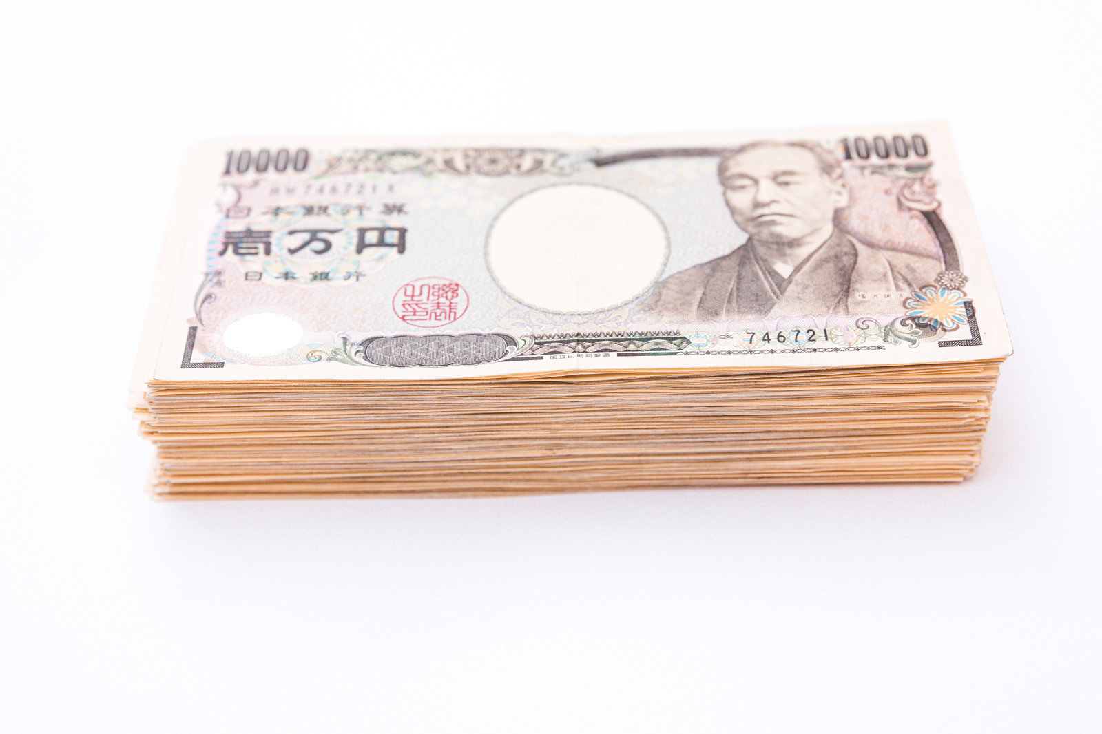 白い背景に積み重ねられた一万円札の束