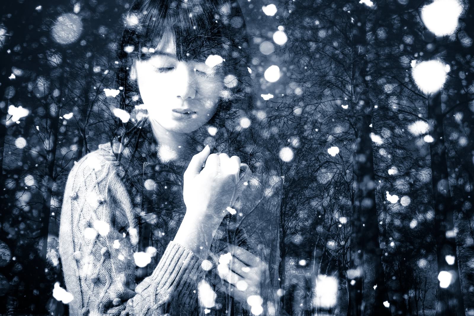 雪が降る中、目を閉じて佇む女性のフォトモンタージュ［モデル：モデルリリース］