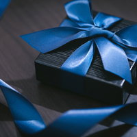 青いリボンで結ばれた高価なプレゼント感のギフトボックスの写真