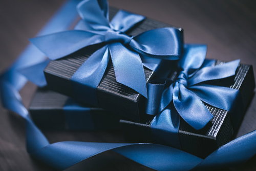 積まれたプレゼント、青いリボンで結ばれた黒いギフトボックス