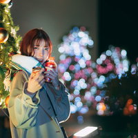 クリスマスツリー前で待ち合わせした彼女が温かい飲み物を買って出迎えてくれたの写真