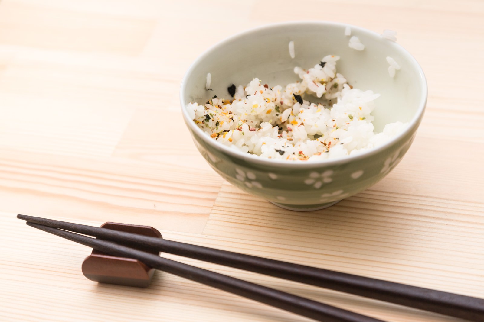 ふりかけをかけた白米の茶碗と黒い箸