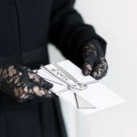 黒い服装で御霊前の不祝儀袋を手渡す場面、法事での香典受け渡しの写真