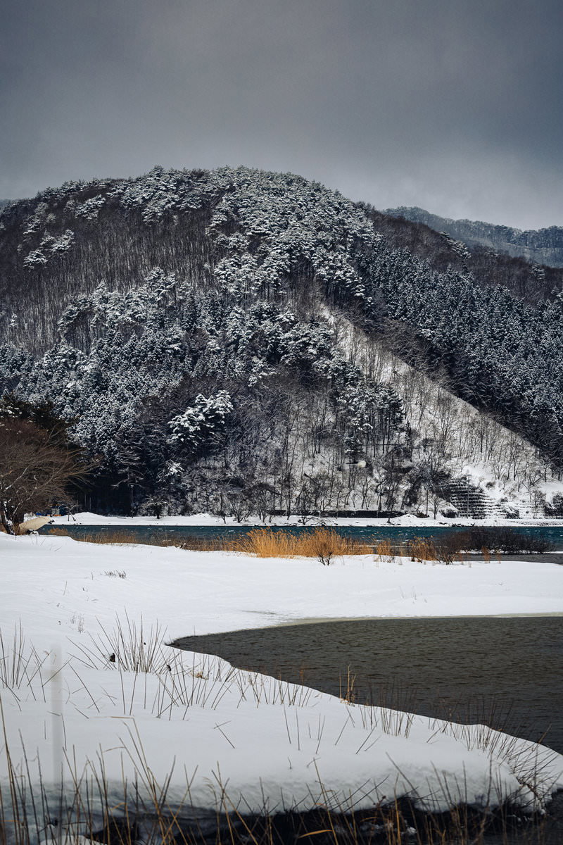 郡山市の湖畔から望む雪山の冬景色