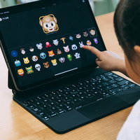 iPadのアニ文字アイコンを選んでタッチする女児の後ろ姿の写真