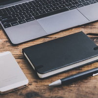 木目のデスクに置かれたPCとスマホの写真