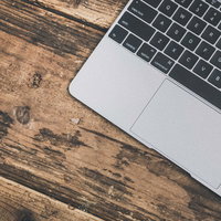 木のテーブルの上のMBAのキーボードの写真