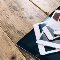 黒いトレーに重ねて置かれたタブレット端末とスマートフォンの写真