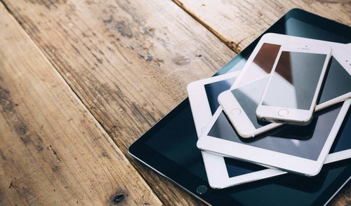 黒いトレーに重ねて置かれたタブレット端末とスマートフォン