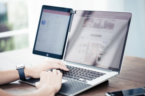 アクセス解析を見ながらノートパソコンでブログデザインを調整するブロガー